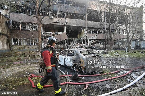 Firefighter walks past a burnt car following a Russian drone strike in Kharkiv on June 11 amid the Russian invasion in Ukraine. Fresh Russian strikes...