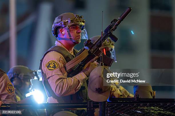 Deputy sheriffs hunt for people roaming the streets after a nighttime curfew takes effect while protests continue in Los Angeles in response to a...
