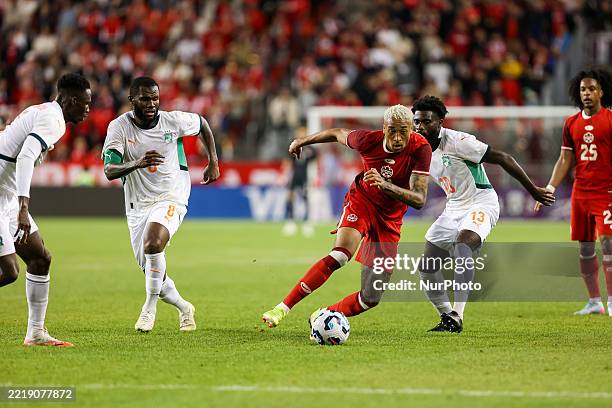 In Toronto, Ontario, Canada, on June 10 Canada attacker Daniel Jebbison tries to run away from Cote D'Ivoire players, including Frank Kessie and...