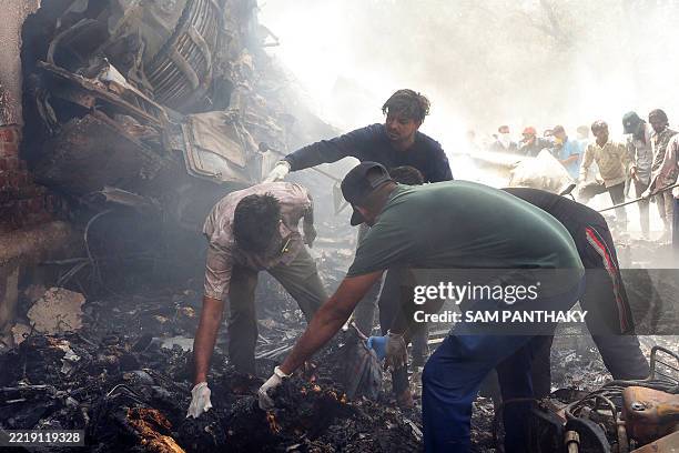 Rescue officials work at the site where Air India flight 171 crashed in a residential area near the airport in Ahmedabad on June 12, 2025. The...