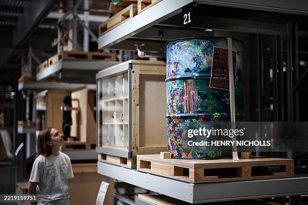 Visitor looks at a Glastonbury Festival painted bin in the main room of the newly opened museum V&A East Storehouse, in East London, on June 12,...