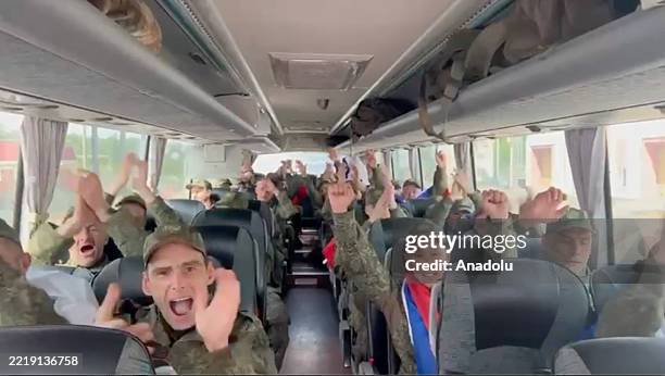 Screen grab taken from a video shows Russian soldiers celebrating inside a bus following a prisoner exchange between Russia and Ukraine under...