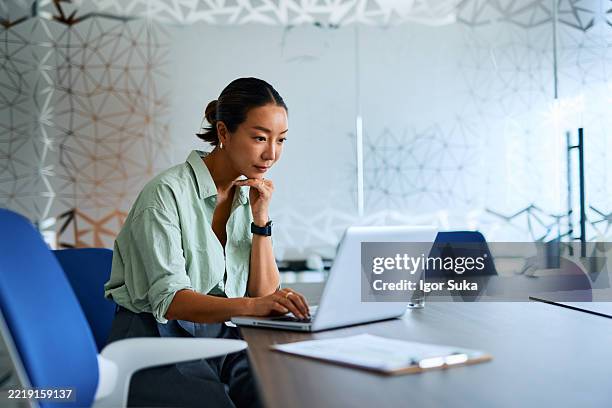 mujer de negocios trabajando en ordenador portátil en la oficina moderna - usar el portátil fotografías e imágenes de stock