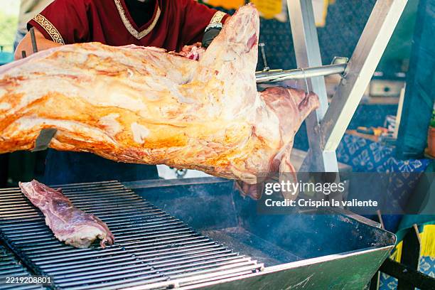 chef grilling whole lamb on a spit over barbecue - spit roasted stock pictures, royalty-free photos & images