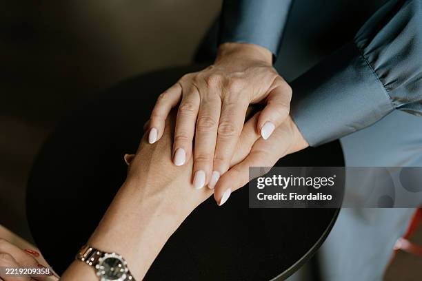 close-up of two hands displaying compassion and supportive gesture - kindness stock pictures, royalty-free photos & images