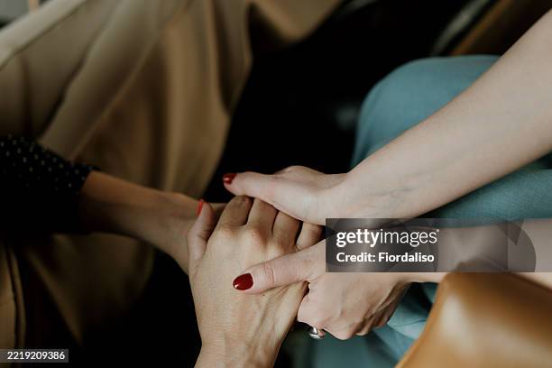 close-up of hands expressing comfort and support in warm surrounding - perdão imagens e fotografias de stock