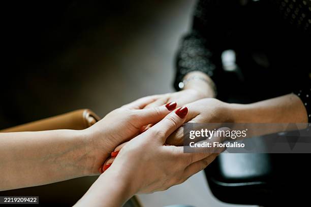 close-up of hands showing comfort and emotional support in a caring gesture - apoio emocional imagens e fotografias de stock