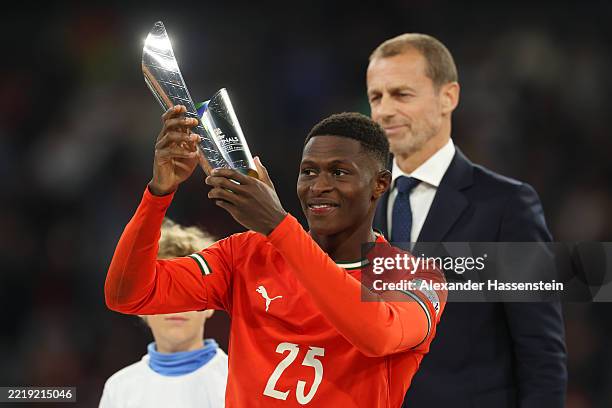 Nuno Mendes of Portugal celebrates with his player of the finals award following victory in the UEFA Nations League 2025 final match between Portugal...