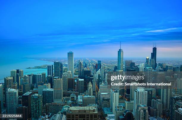 aerial chicago "skyline" partially illuminated at early dusk with iconic skyscrapers (willis tower, aon center, trump tower) and lake michigan waters visible under romantic sky in chicago, illinois, usa - magnificent mile stock pictures, royalty-free photos & images