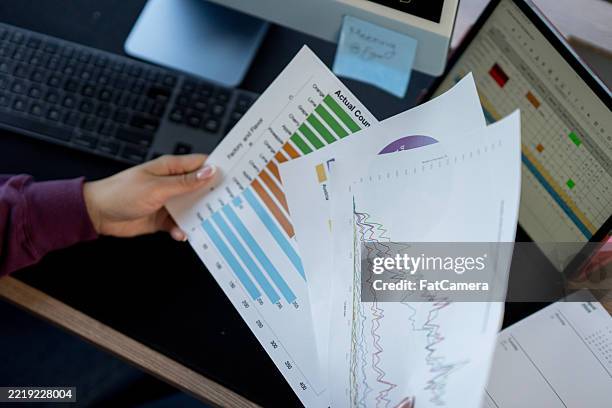 professional analyzing graphical data in a modern office setting - identidade corporativa imagens e fotografias de stock