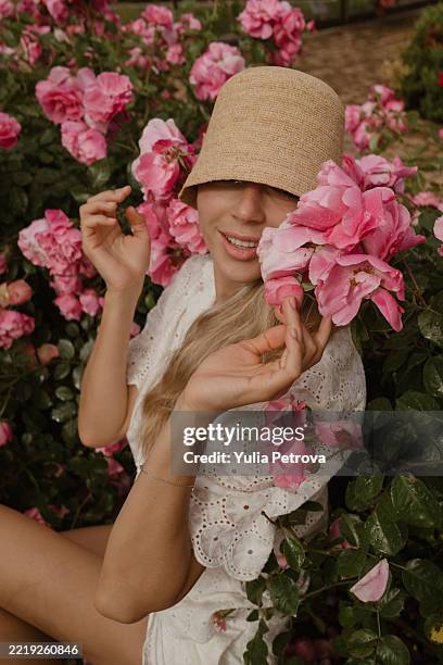 portrait of a woman with roses - junge frau allein stock-fotos und bilder