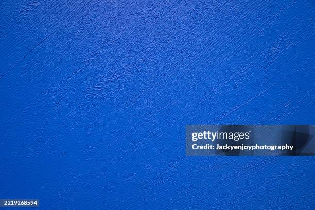 the backdrop is dark blue with a texture reminiscent of an ancient grunge wall. - pared azul fotografías e imágenes de stock