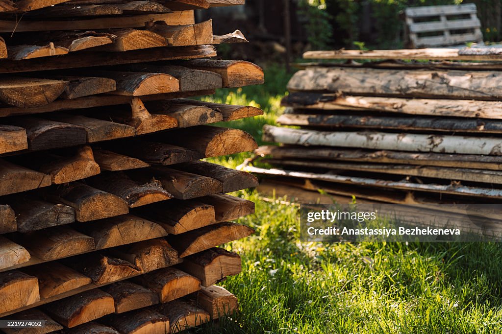 Cut firewood in a tight pile, ready for burning. Natural patterns in aged, sunlit wood