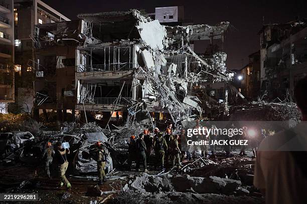 Graphic content / Israeli troops and first responders gather in an area hit by a missile fired from Iran, in Ramat Gan near Tel Aviv on June 13,...