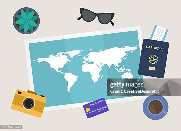 travel planning concept. high angle view of table with world map, passport, airplane ticket, credit card, camera and sunglasses - travel essentials stock illustrations