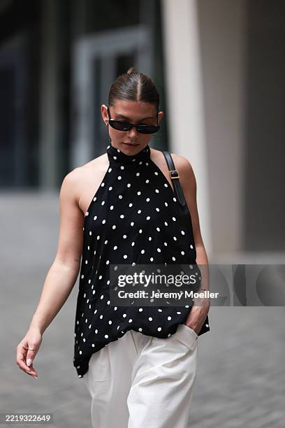 Sophia Geiss is seen wearing silver hoop earrings in two different sizes; narrow oval black sunglasses from Saint Laurent; a silver nose ring; a...
