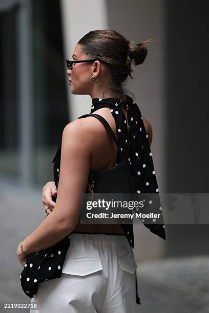 Sophia Geiss is seen wearing silver hoop earrings in two different sizes; narrow oval black sunglasses from Saint Laurent; a silver nose ring; a...
