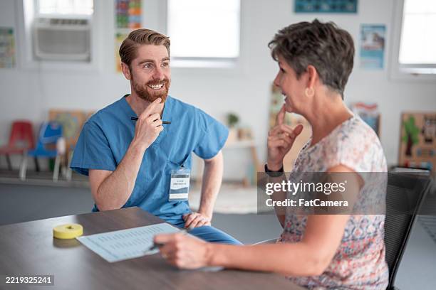 therapist engaging with patient during occupational speech therapy session - terapia ocupacional imagens e fotografias de stock