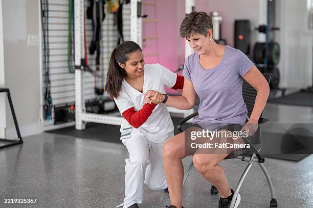 physiotherapeut, der den patienten während der rehabilitationssitzung bei der übung unterstützt - ergotherapie stock-fotos und bilder