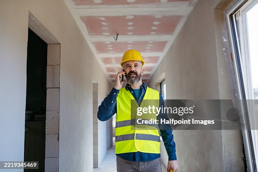Construction manager making phone call while inspecting progress on building site. Construction manager making phone call while inspecting progress on building site.