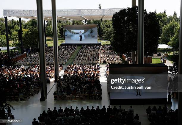 Attendees watch Apple senior vice president of software engineering Craig Federighi speak during the Apple Worldwide Developers Conference on June...