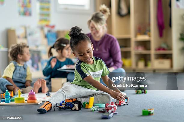 children enjoying playtime activities in a vibrant daycare setting - preschool student stock pictures, royalty-free photos & images