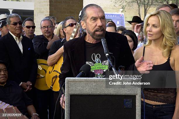 View of married American businesspersons John Paul DeJoria & Eloise Broady DeJoria at a lectern during a ceremony to dedicate a historical marker at...