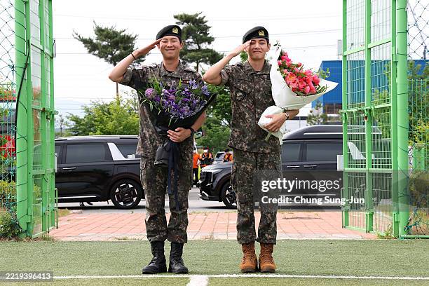 Pop band BTS's members RM and V salute after being discharged from a mandatory military service on June 10, 2025 in Chuncheon, South Korea. Four...