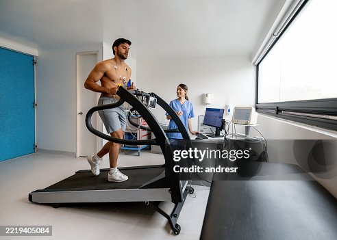Man running on a treadmill while doing a stress test at a sports training clinic Man running on a treadmill while doing a stress test at a sports training clinic