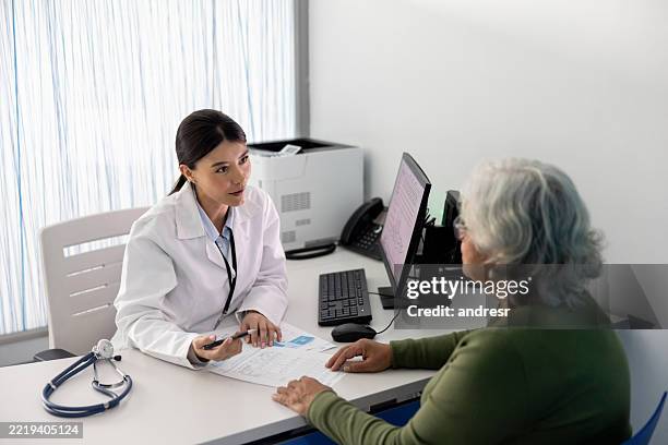 arzt erklärt einer älteren frau die ergebnisse ihrer medizinischen untersuchungen - medizinische testergebnisse stock-fotos und bilder