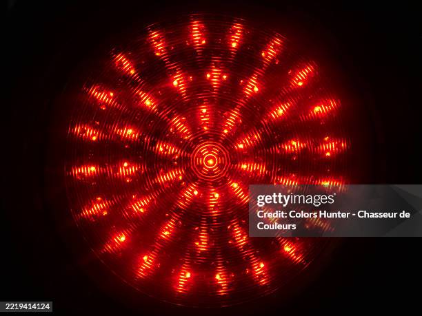 close-up of a illuminated red light traffic on a black background. rough texture. natural colors. paris, france. 4:3 format. - rote ampel stock-fotos und bilder