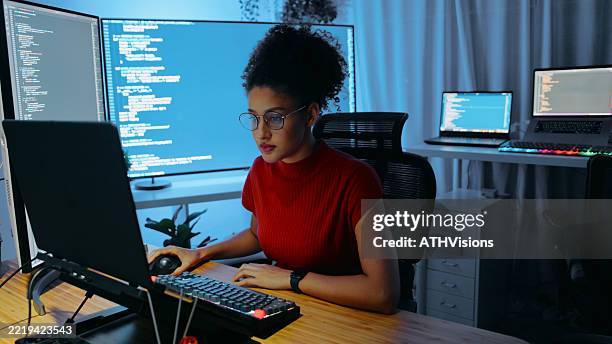 sviluppatore di software femminile che codifica in un moderno ufficio tecnologico con più monitor - programmazione televisiva foto e immagini stock