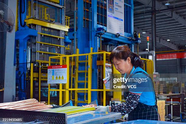 An employee works on the production line of air conditioner heat exchangers at a new energy technology company on June 10, 2025 in Anqing, Anhui...