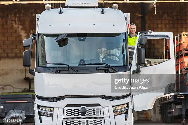 truck driver stands at the door of his white truck with trailer - electric delivery truck stock pictures, royalty-free photos & images
