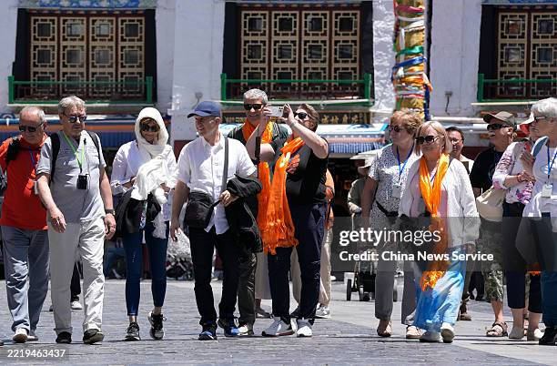 Foreign tourists stroll down the Barkhor Street, a well-known circumanbulation and commercial center with unique Tibetan tradition and culture, on...