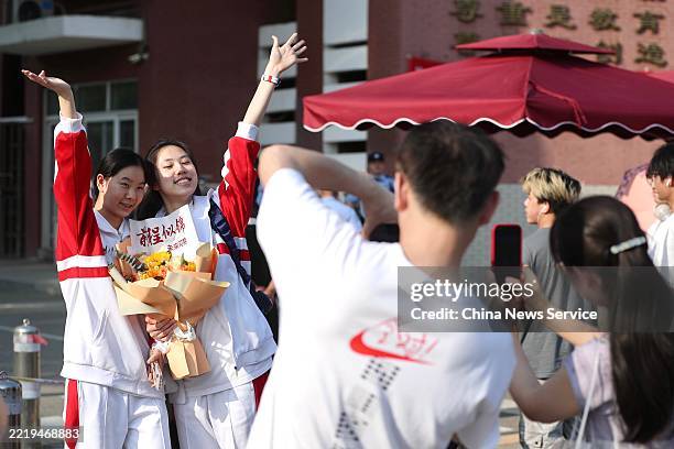 Gaokao candidates pose with flowers after the exam at a national college entrance examination site on June 10, 2025 in Beijing, China. China's...