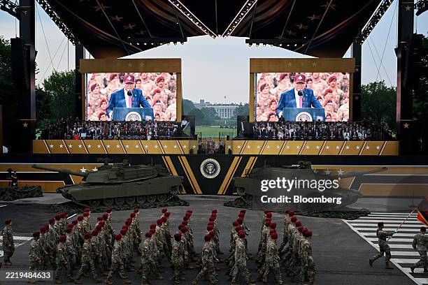 President Donald Trump, on screen, as members of the military march during the US Army's 250th Anniversary Parade in Washington, DC, US, on Saturday,...