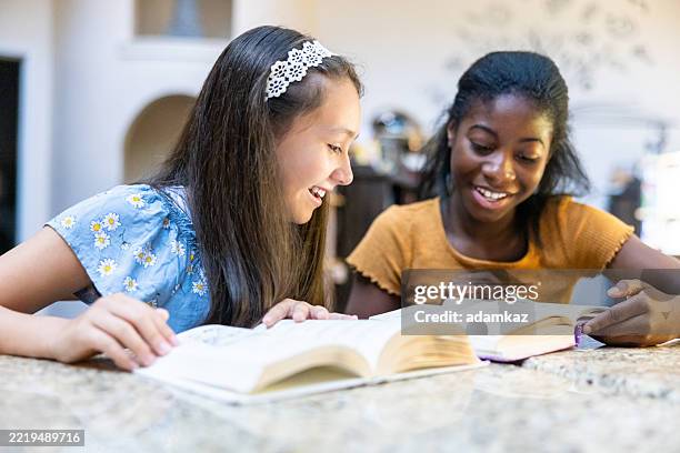 two middle school aged girls reading in the library - junior high student stock pictures, royalty-free photos & images