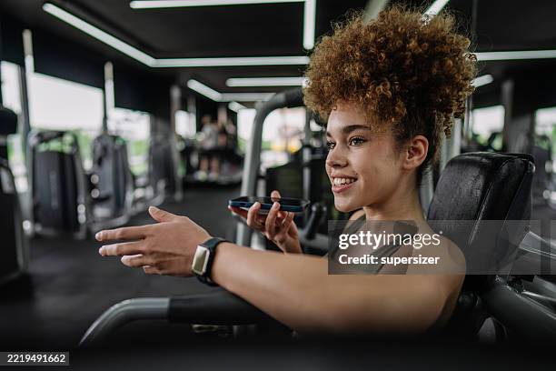 young woman engaged in fitness activity at gym. - conference phone stock pictures, royalty-free photos & images