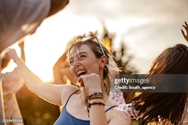 capturer la joie d’une foule diversifiée dansant ensemble lors d’un festival de musique en plein air au coucher du soleil - festival de musique photos et images de collection