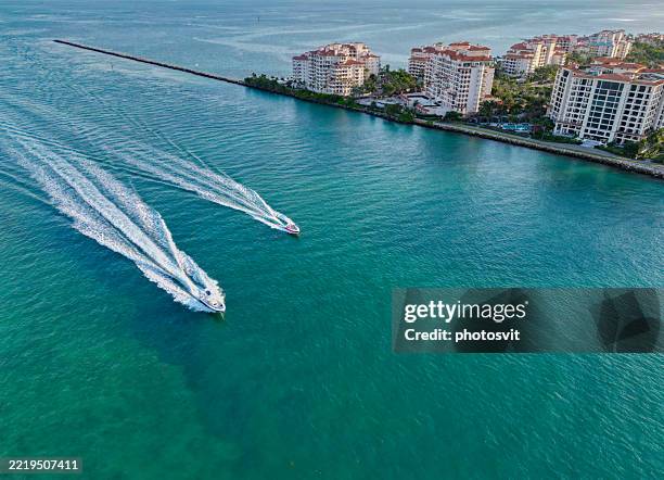 Luxury boat motor yacht. Luxury yacht go to marina. Boating and yachting. Luxury lifestyle. Yacht at Fisher island luxury residential building. Vacation on summer. Fisher island building. Copy space
