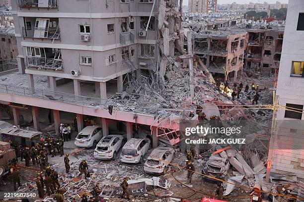 Responders work amid building rubble following a strike by an Iranian missile in the Israeli city of Bat Yam, south of Tel Aviv, early on June 15,...