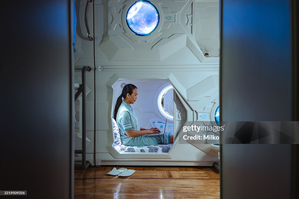 Individual working inside a futuristic capsule during night