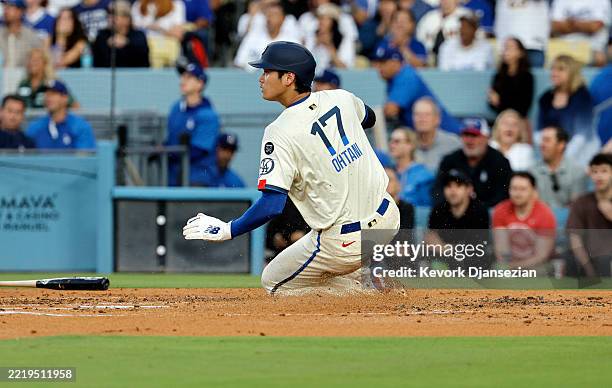 Shohei Ohtani of the Los Angeles Dodgers slides at home plate safely to score a run against the San Francisco Giants during the second inning at...