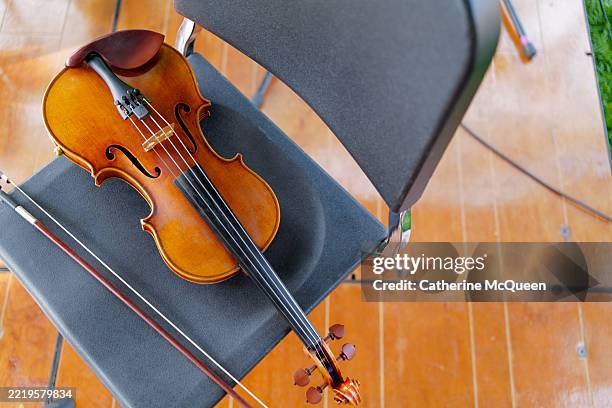 violin & bow on chair on stage - violino imagens e fotografias de stock