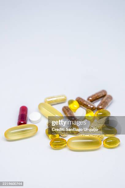 close-up of vitamin and antioxidant capsules - gold capsules stock pictures, royalty-free photos & images