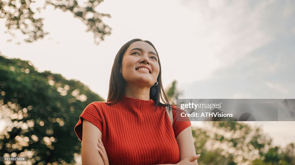 Smiling woman enjoying nature and freedom in sunny park setting