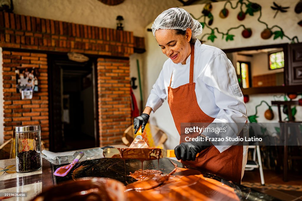 Reife Konditorin, die zu Hause Schokolade zubereitet
