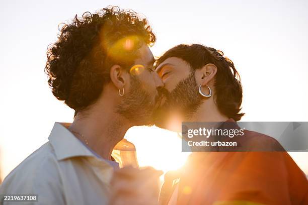 pareja gay masculina mediana adulta besos en la calle en barcelona en españa - beso fotografías e imágenes de stock