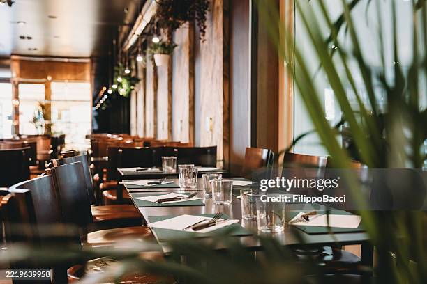 empty tables awaiting customers in a modern restaurant - gedekte tafel stockfoto's en -beelden